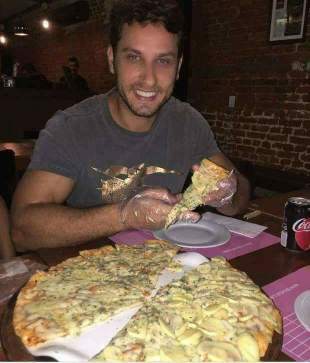 O ex-BBB Eliéser degustando uma bela pizza de luvinha