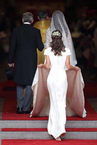 Pippa Middleton segurando a cauda do vestido da irmã Kate no casamento Real