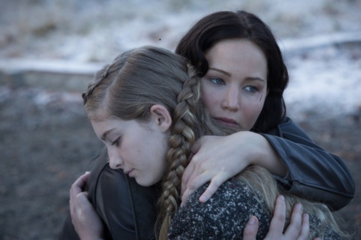 Katniss Everdeen (Jennifer Lawrence) abraça a irmã Prim (Willow Shields) 