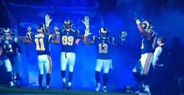Jogadores do St. Louis Rams repetem o gesto antes do jogo contra o Oakland Raiders