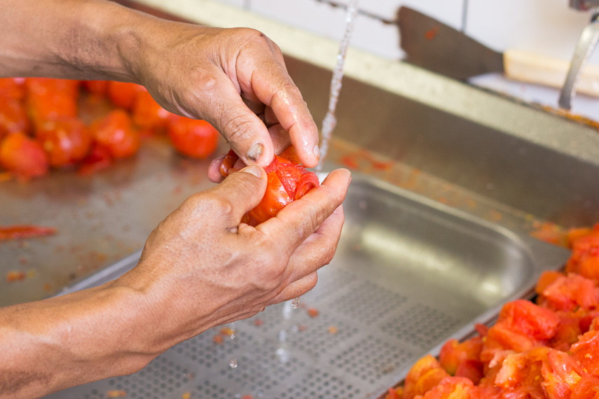 7 - Na pia, embaixo da água corrente, vá tirando as peles. Aproveite para abrir os tomates, com a mão mesmo e ir tirando um pouco (50%) das sementes 