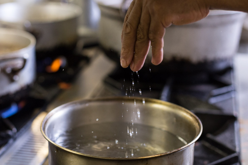 No La Grassa, a dica é colocar um punhado de sal grosso na água. O chef pega o sal com a ponta dos dedos e joga na água. Geralmente, são 10 gramas de sal para cada 1 litro de água. Lembre-se: a proporção adequada é de cerca de 1 litro de água para cada 100g de massa