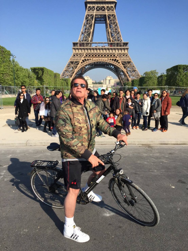 Olha aí o Schwarzenegger atrapalhando a selfie turística de uma galera em Paris